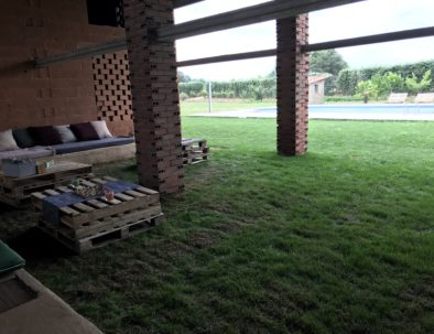 Zona chill out cubierta con cesped natural y piscina al fondo casa rural Apayama La Vera Cáceres Extremadura